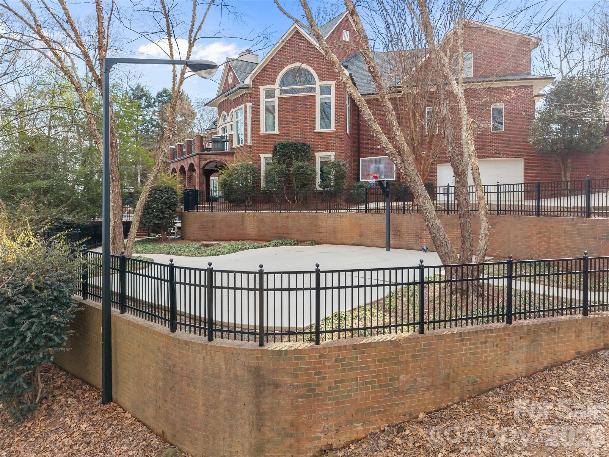 8052 Westbay Road Denver, NC 28037 - Photo 39 of 45 a view of a brick house with a small yard and a large tree