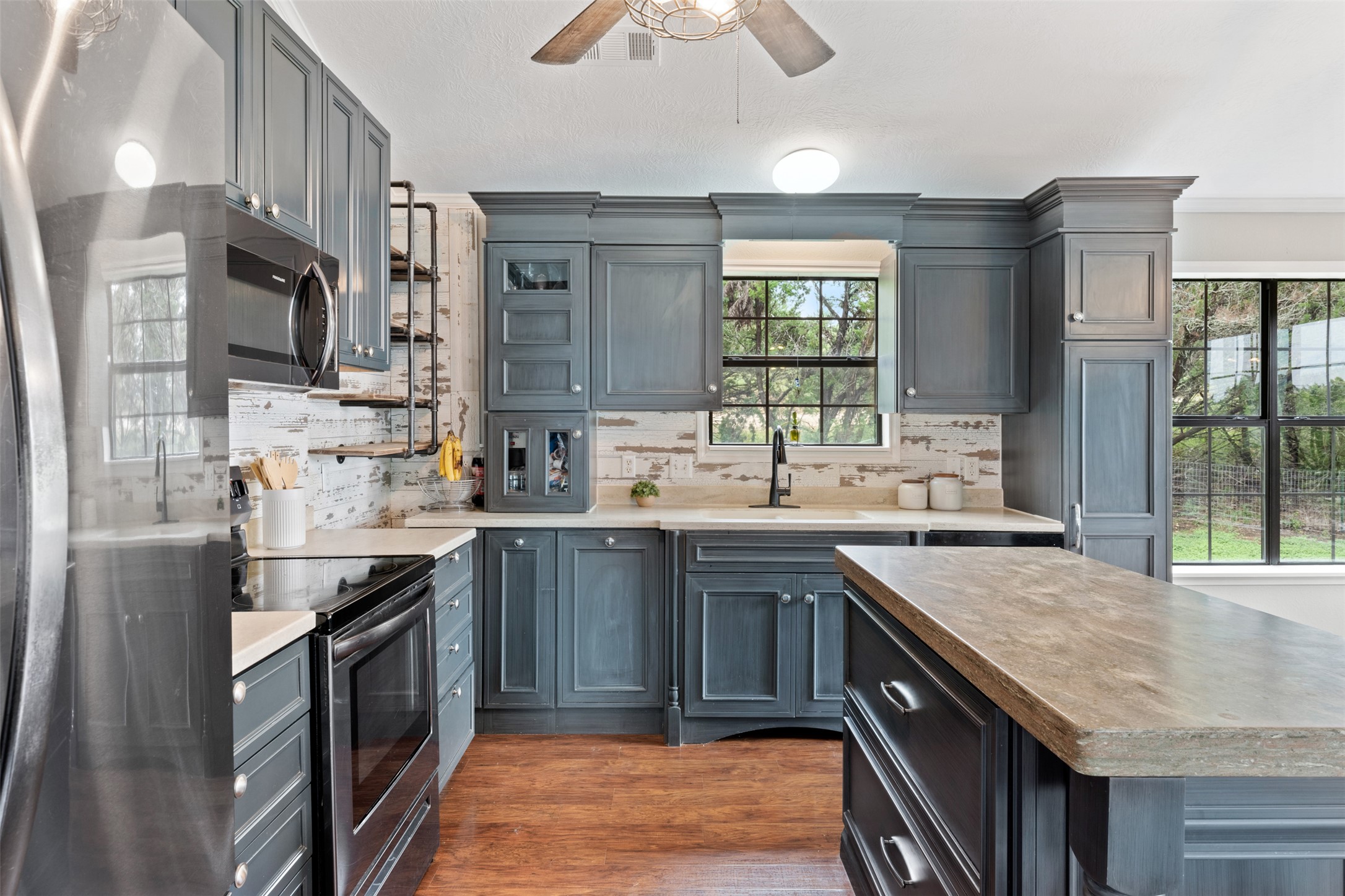 250 Kothmann Road Dripping Springs, TX 78620 - Photo 1 of 1 Kitchen featuring dark wood-style floors, appliances with stainless steel finishes, backsplash, and a sink
