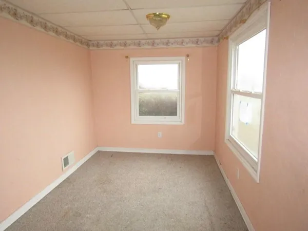 an empty room with closet and a ceiling fan