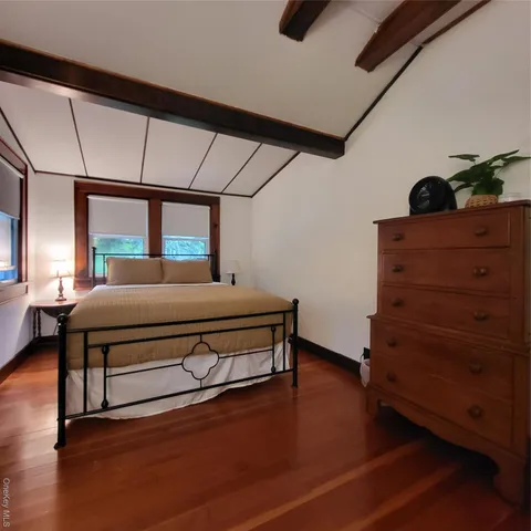 a bedroom with furniture and wooden floor