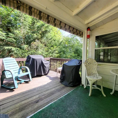 a view of a chair and table in backyard of the house