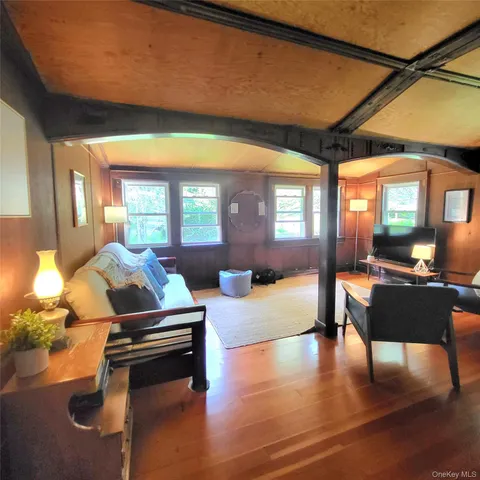 a living room with furniture a table and wooden floor