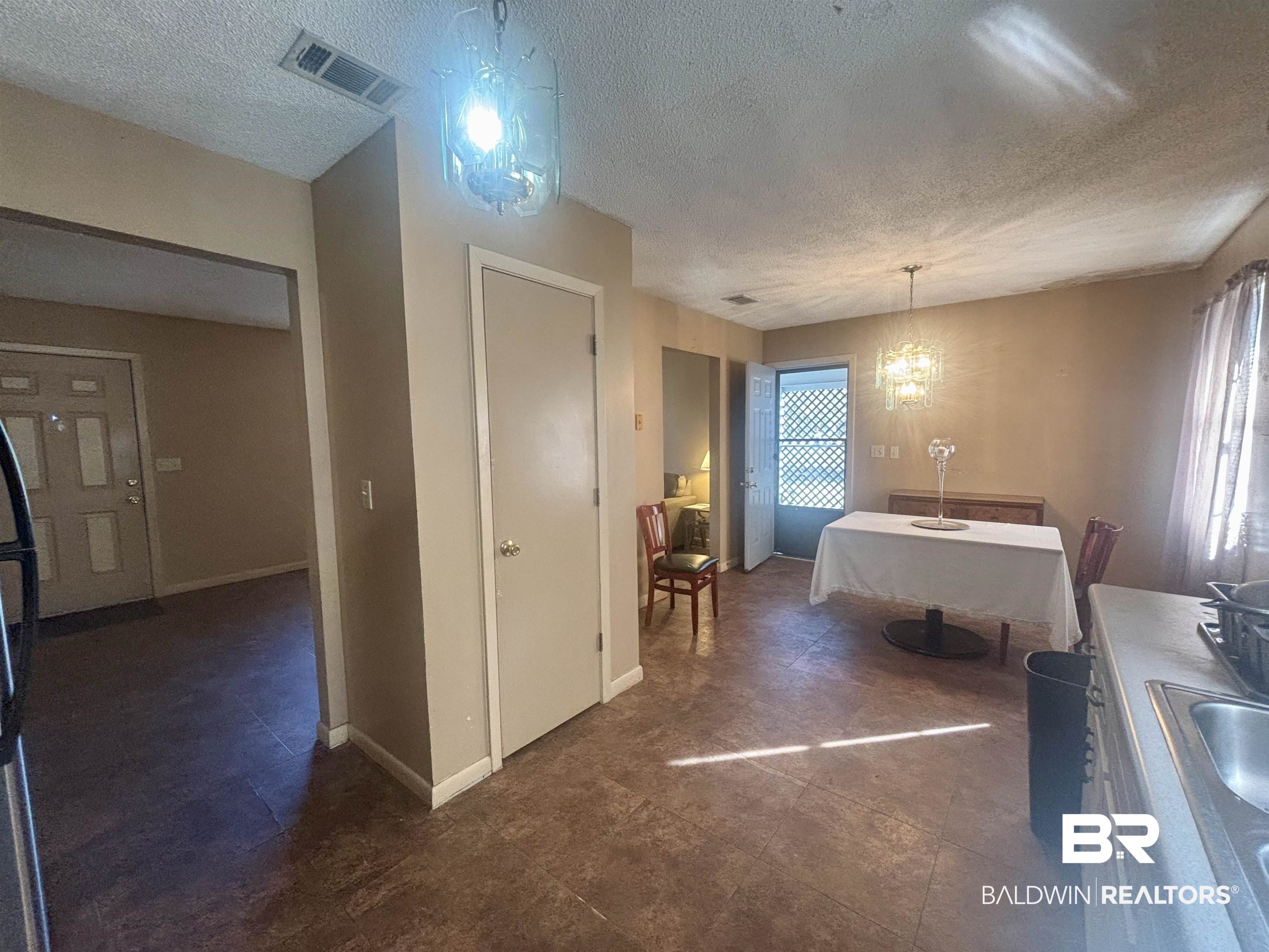320 South Pecan Street Foley, AL 36535 - Photo 5 of 17 Interior space featuring a notable chandelier, hanging light fixtures, and a textured ceiling