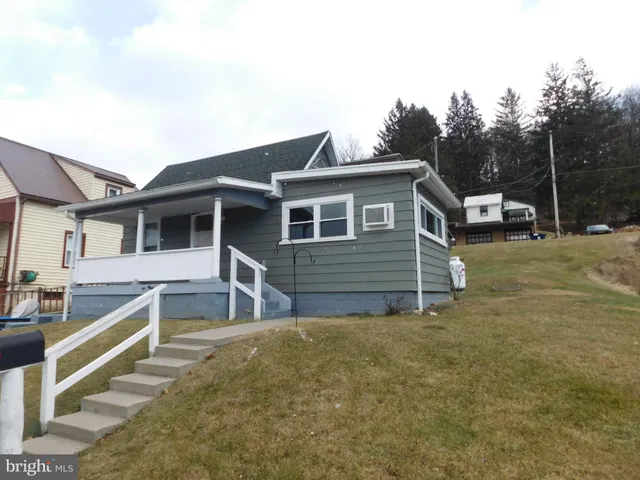 a view of a house with a small yard and wooden fence
