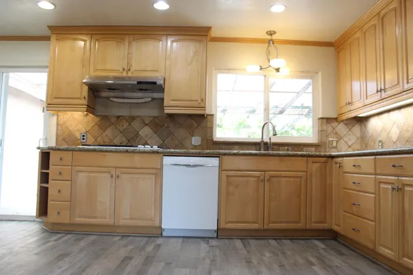 a kitchen with stainless steel appliances granite countertop a sink a stove and cabinets