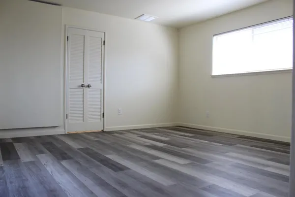 a view of a room with wooden floor and windows