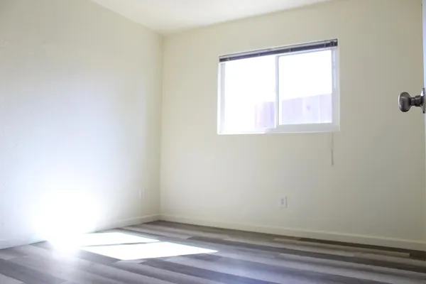 a view of a room with wooden floor and a ceiling fan