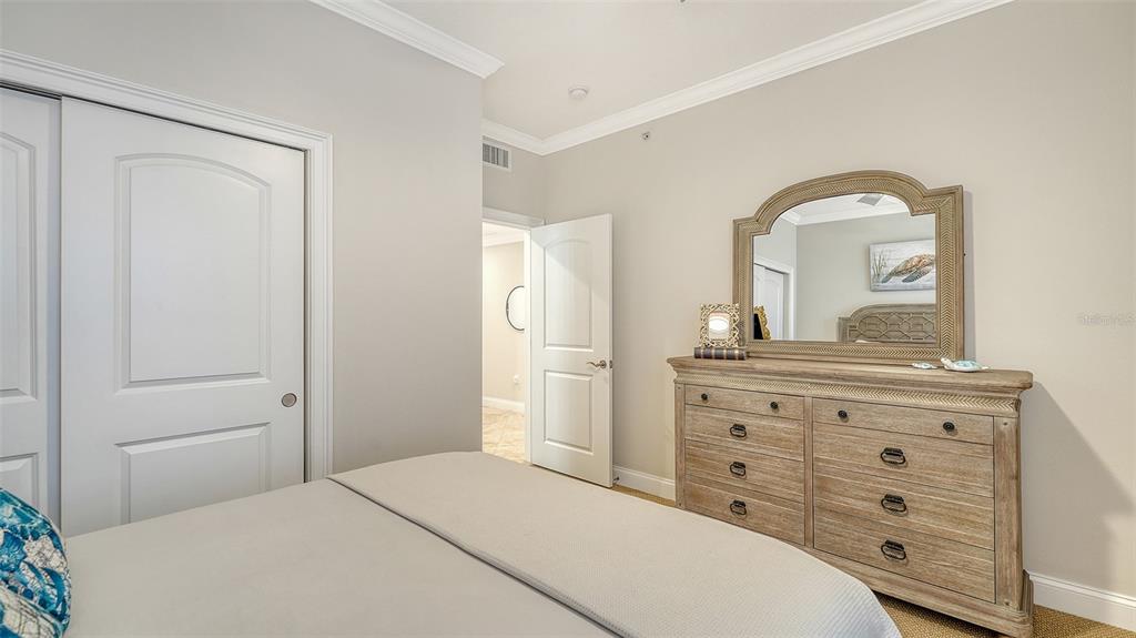 606 Riviera Dunes Way, Unit 306 Palmetto, FL 34221 - Photo 38 of 64 a bedroom with a bed and a dresser