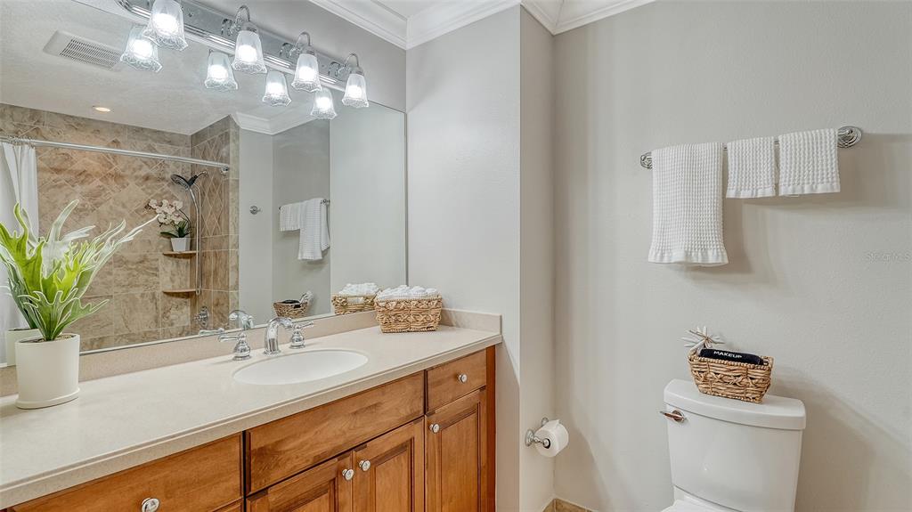 606 Riviera Dunes Way, Unit 306 Palmetto, FL 34221 - Photo 39 of 64 a bathroom with a sink a large mirror and a toilet