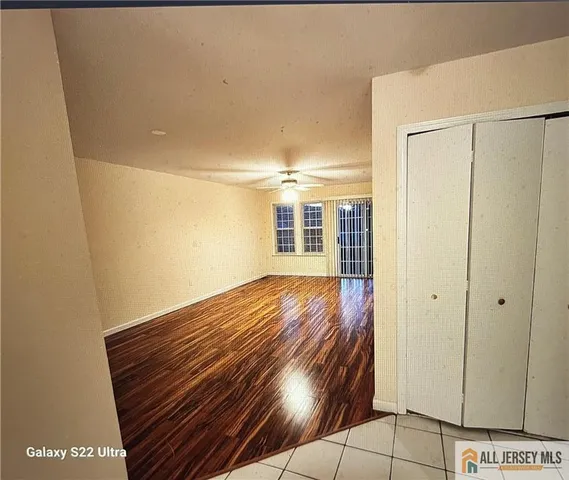 a view of empty room with wooden floor