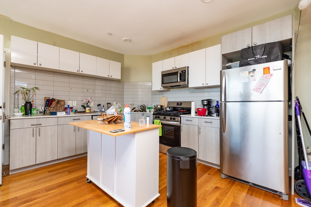 299 Dudley Street Boston, MA 02119 - Photo 10 of 18 a kitchen with stainless steel appliances granite countertop a refrigerator and a stove top oven