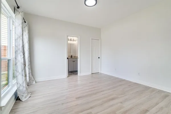 a view of a hallway with wooden floor and windows