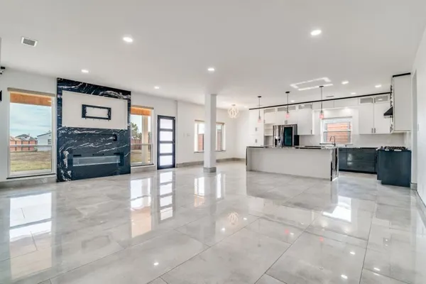 a large white kitchen with a refrigerator a stove top oven and cabinets