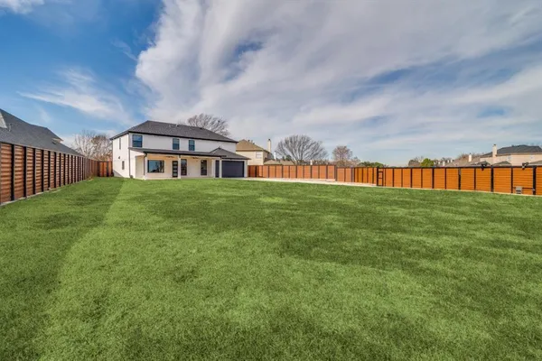 a view of a big house with a big yard and large trees