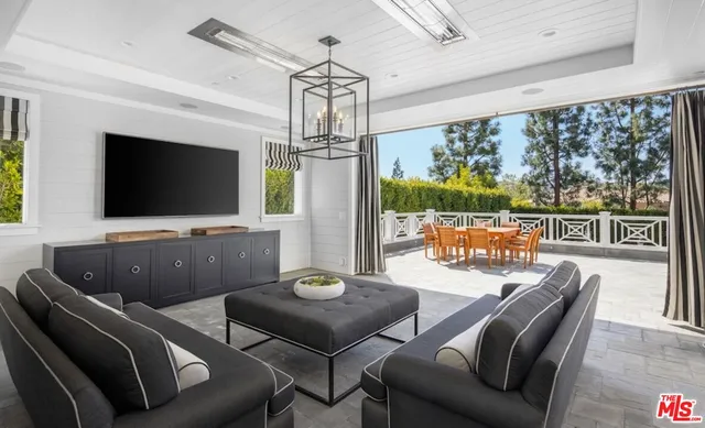 a living room with furniture a flat screen tv and a floor to ceiling window