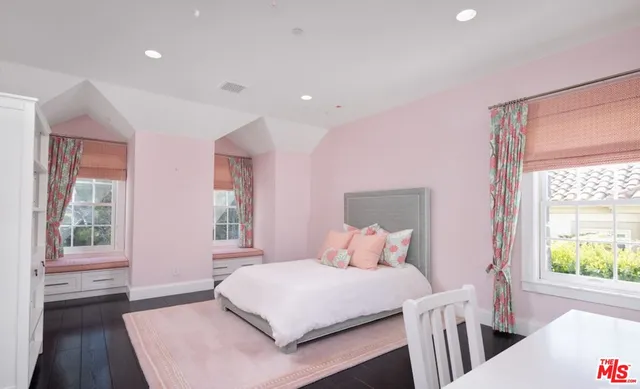 a bathroom with a toilet a sink a vanity a mirror and a window