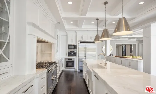 a large kitchen with granite countertop a large stove a sink dishwasher and a refrigerator with wooden floor