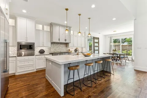 a kitchen with granite countertop a sink stove and refrigerator