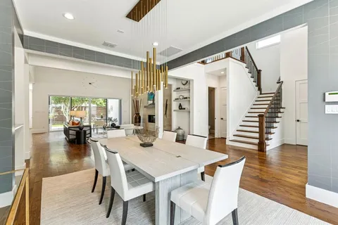 a dining room with furniture a chandelier and wooden floor