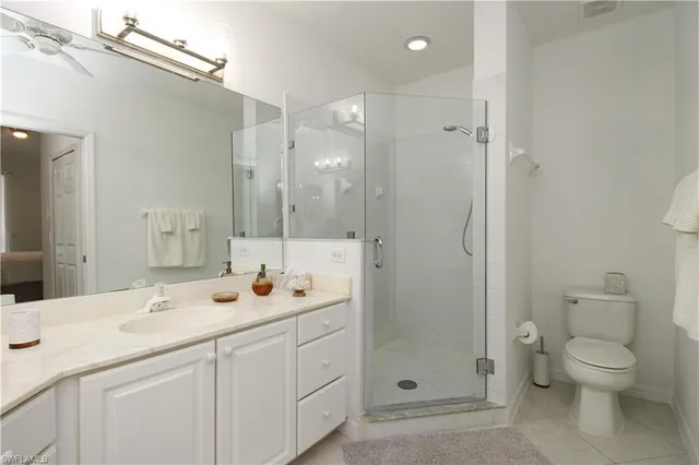 a bathroom with a granite countertop sink a toilet and shower