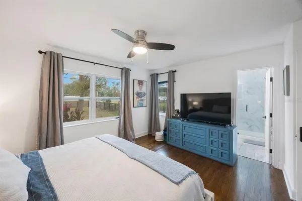 a bedroom with a bed and a flat tv screen on dresser