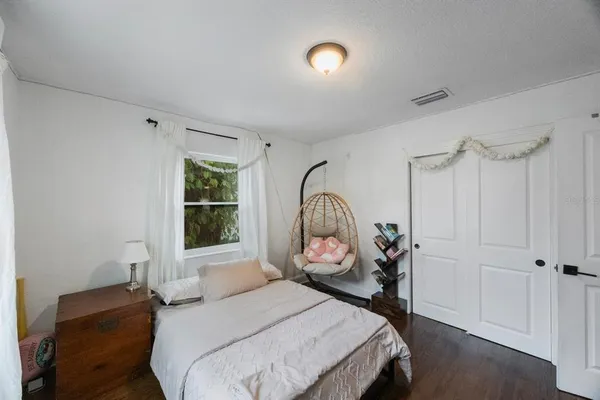 a bedroom with a bed a chandelier and a window