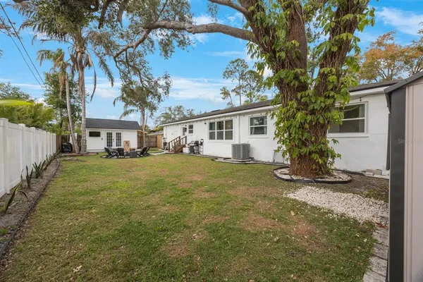 a view of a yard in front of a house with a large tree