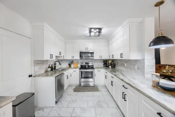 a kitchen with stainless steel appliances granite countertop a sink and a stove