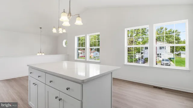 a kitchen with kitchen island a sink a center island stainless steel appliances and a window