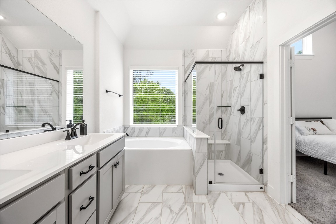 219 Prairie Rose Court Conroe, TX 77318 - Photo 31 of 49 a spacious bathroom with a double vanity sink a mirror a bathtub and next to a window