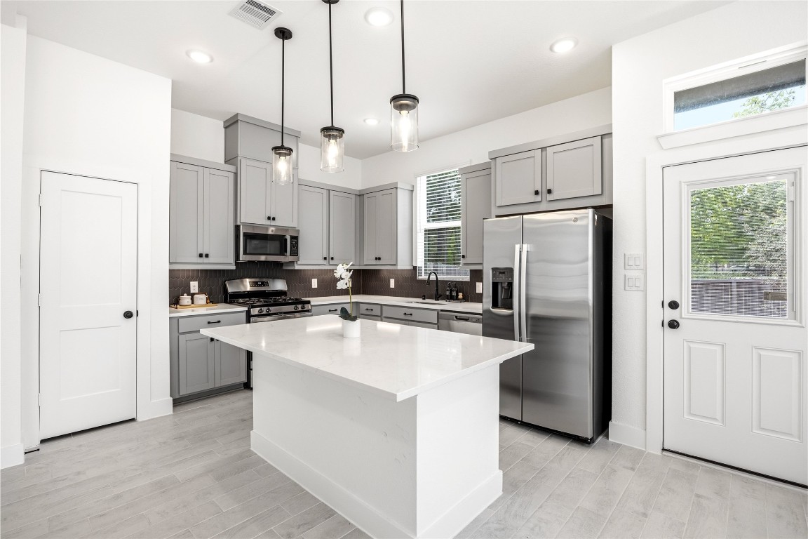 219 Prairie Rose Court Conroe, TX 77318 - Photo 9 of 49 a kitchen with white cabinets and stainless steel appliances