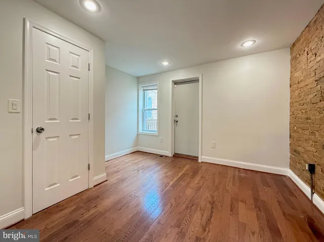 a view of an empty room with wooden floor