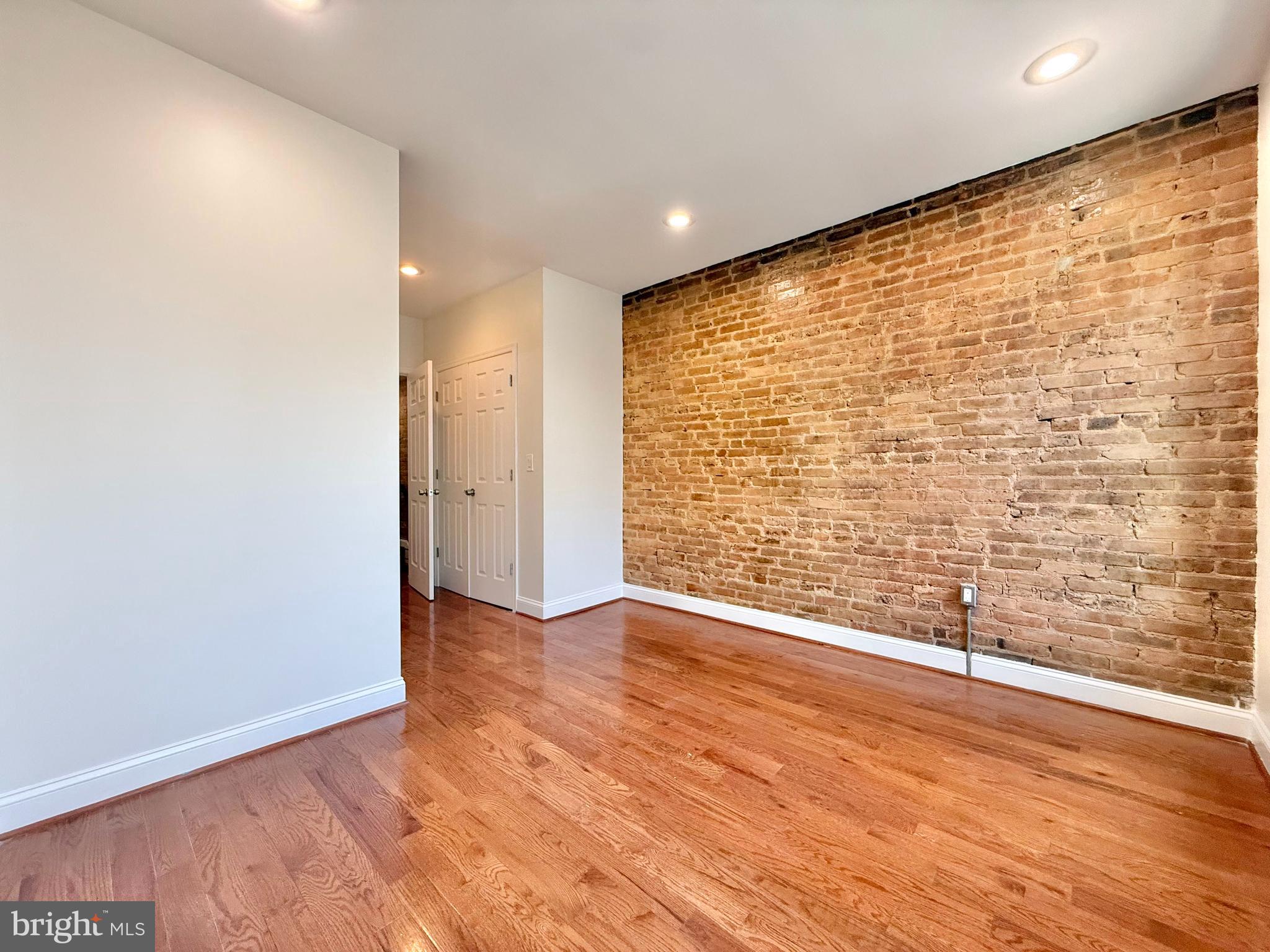 1268 Glyndon Avenue Baltimore, MD 21223 - Photo 20 of 30 a view of an empty room with wooden floor and a window