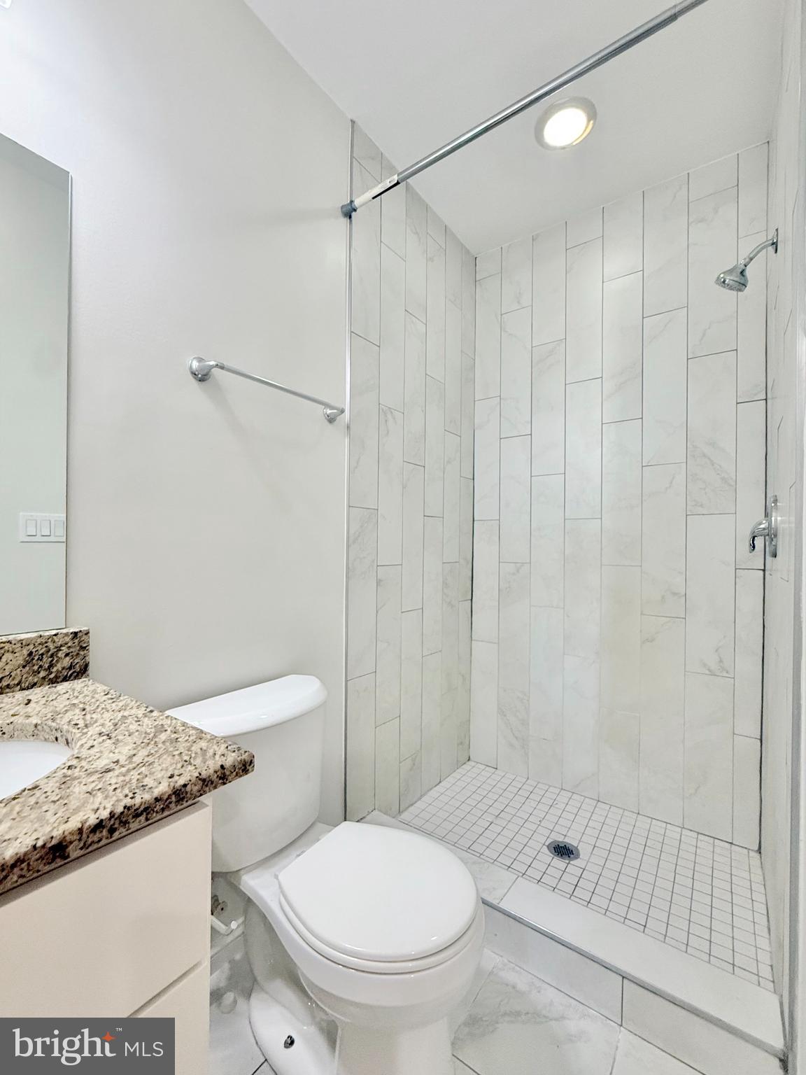 1268 Glyndon Avenue Baltimore, MD 21223 - Photo 22 of 30 a bathroom with a granite countertop sink a toilet and shower