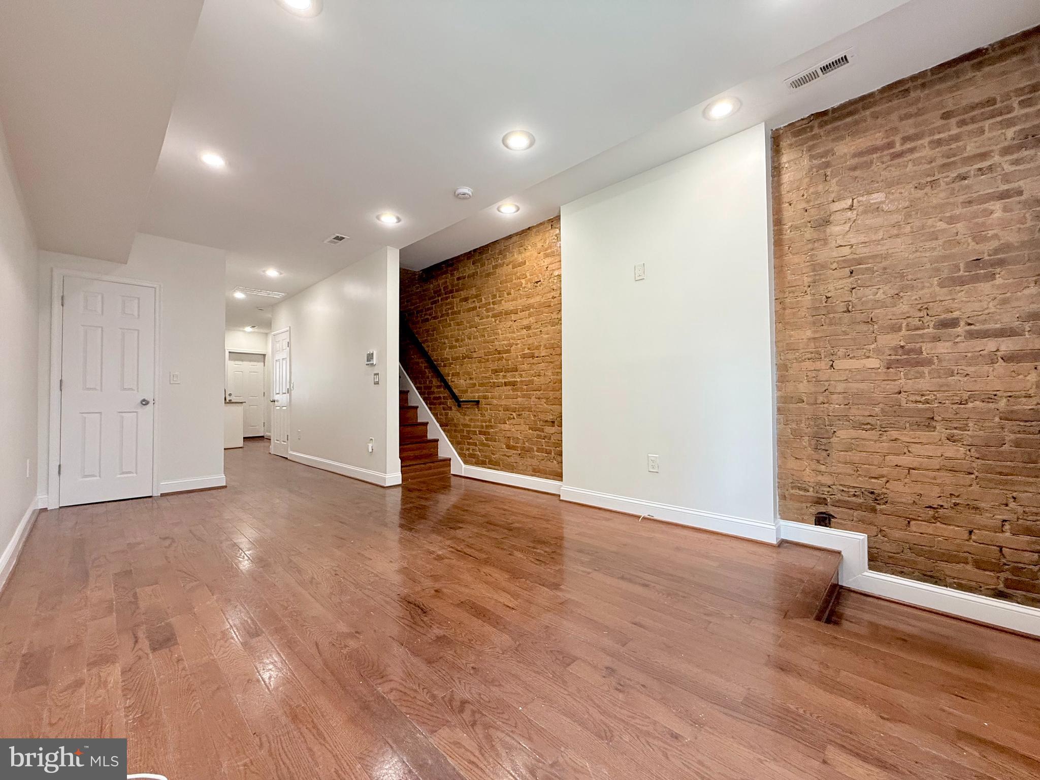 1268 Glyndon Avenue Baltimore, MD 21223 - Photo 3 of 30 a view of an empty room with wooden floor and a window