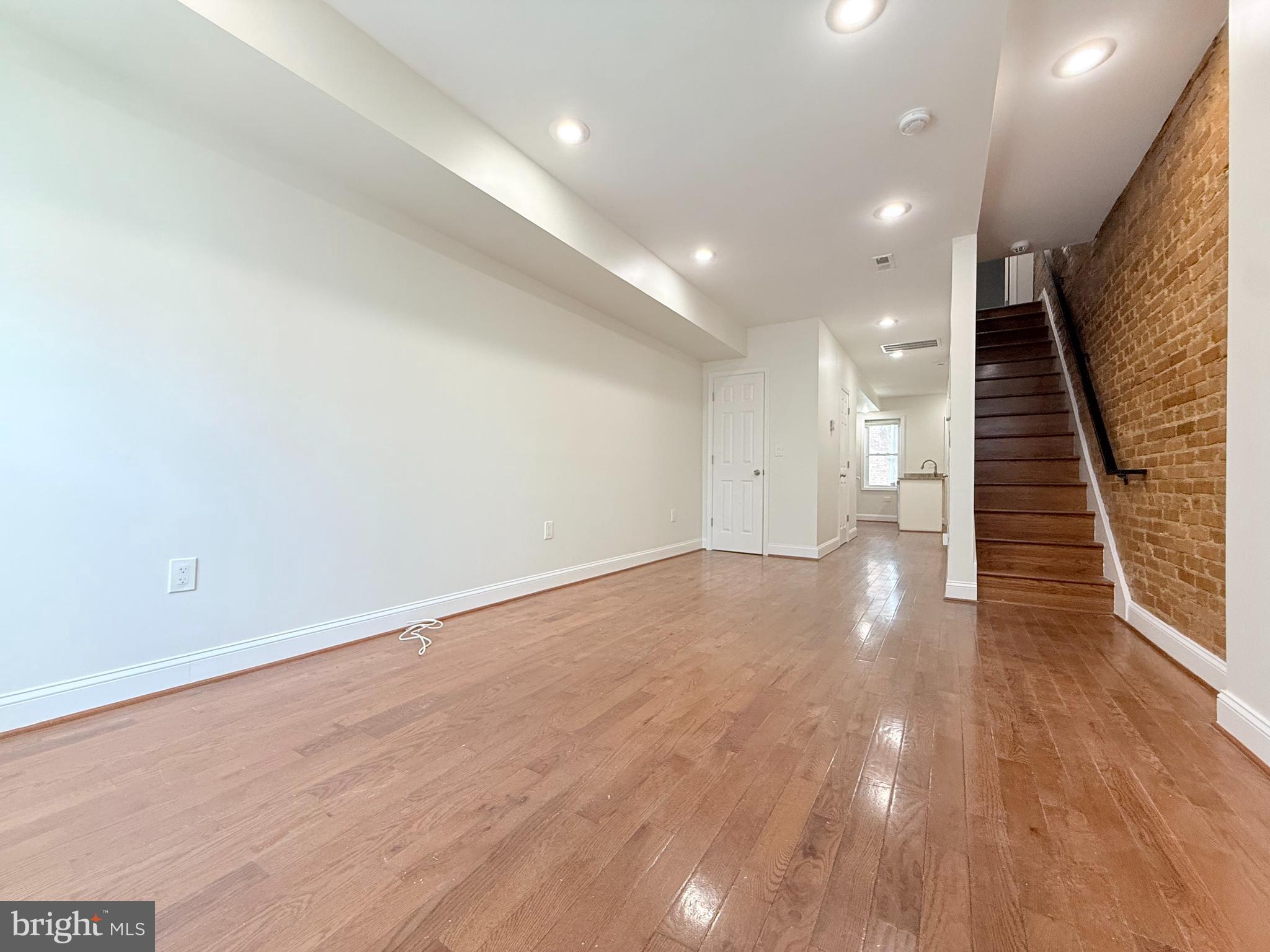 1268 Glyndon Avenue Baltimore, MD 21223 - Photo 4 of 30 an empty room with wooden floor and windows