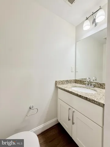 a bathroom with a granite countertop toilet and sink
