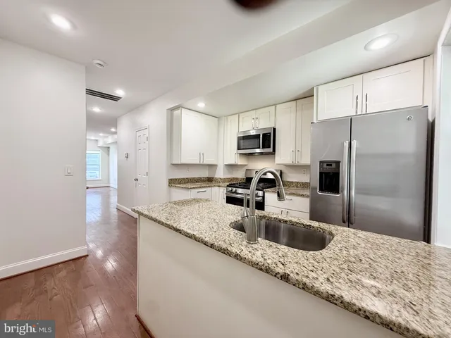 a kitchen with stainless steel appliances granite countertop a sink refrigerator and microwave