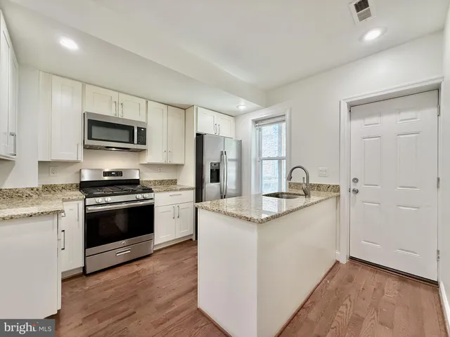 a kitchen with stainless steel appliances granite countertop a stove a sink and a refrigerator