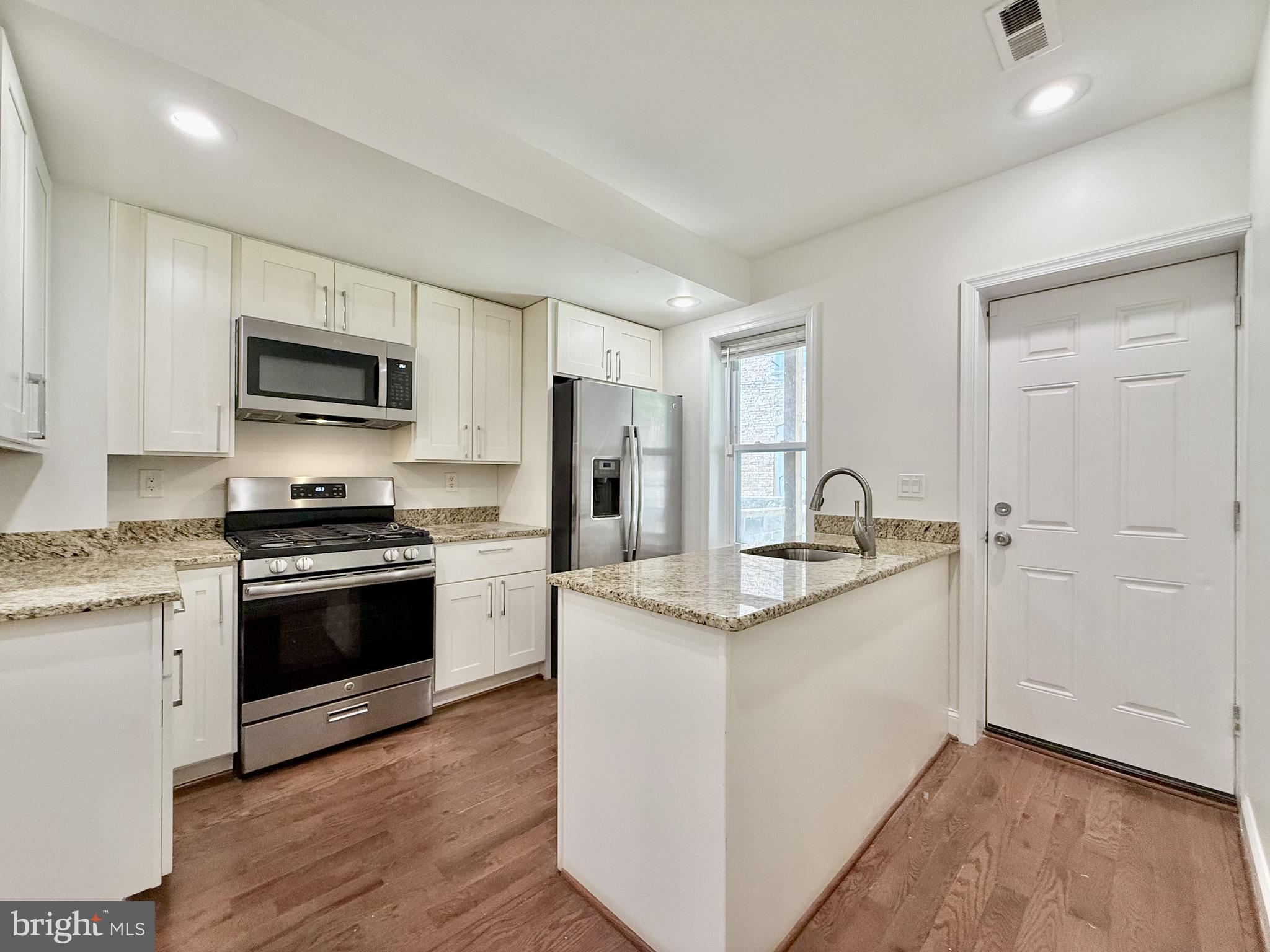 1268 Glyndon Avenue Baltimore, MD 21223 - Photo 8 of 30 a kitchen with stainless steel appliances granite countertop a stove a sink and a refrigerator