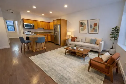 a living room with furniture and kitchen view