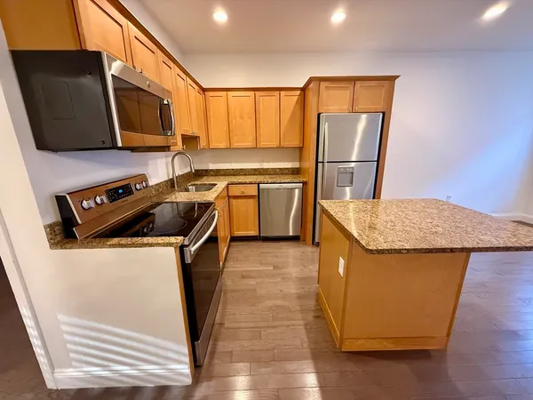 a kitchen with a refrigerator a stove top oven a sink and dishwasher