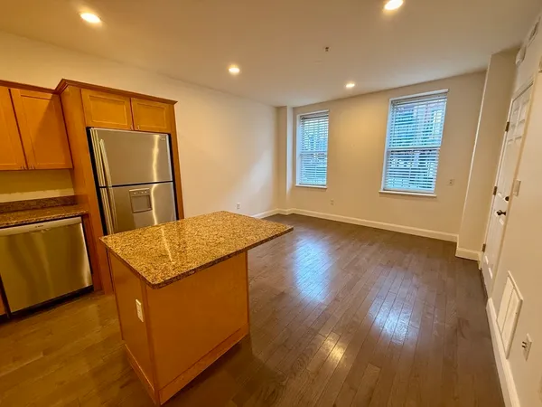 a view of a kitchen with fridge and wooden floor