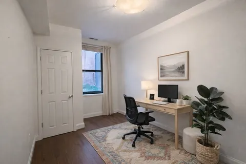a view of a workspace with furniture and a window