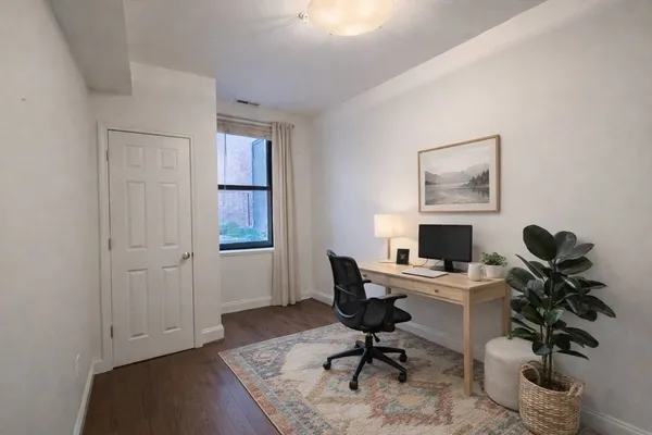 a view of a workspace with furniture and a window