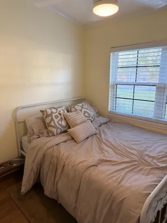 a bed sitting in a bedroom next to a window