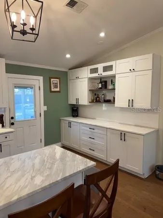a kitchen with a sink cabinets and wooden floor