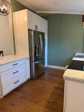 a kitchen with a refrigerator sink and cabinets