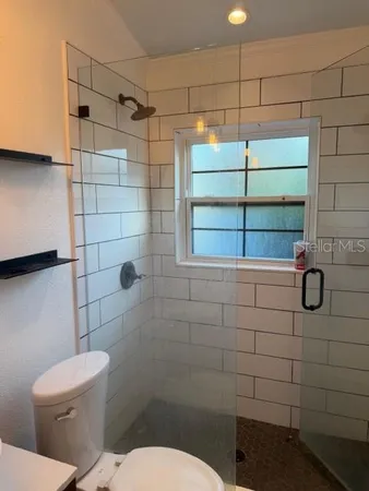 a bathroom with a toilet and a shower