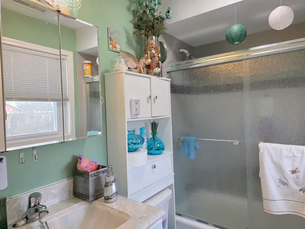 a bathroom with a shower sink and mirror